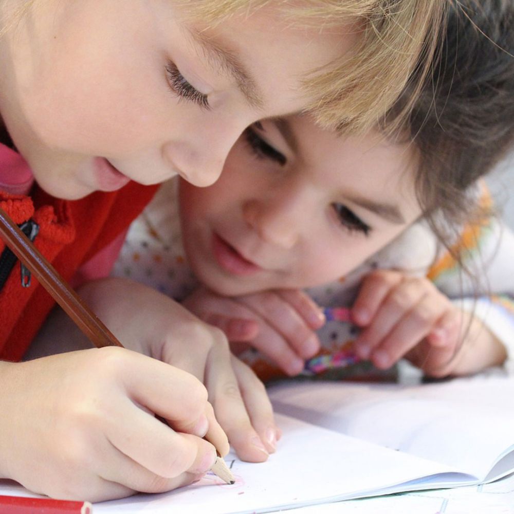 Bambini disegnano su un quaderno
