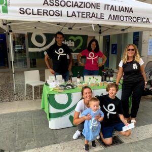 Alcuni volontari e volontarie (bambini, adolescenti e adulti) dell’Associazione Italiana Sclerosi Laterale Amiotrofica presso un banchetto di raccolta fondi.