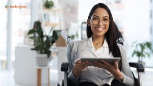 Una giovane donna in sedia a rotelle tiene in mano un tablet.