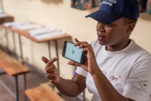 Un’operatrice del CMB mentre utilizza Peek Vision, un’applicazione per smartphone che consente rapidi test visivi anche in ambienti remoti e con risorse limitate.