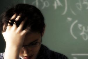 Un giovane studente con dislessia si mette una mano nei capelli mentre studia.