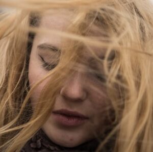 Primo piano di una donna con i capelli sul viso.