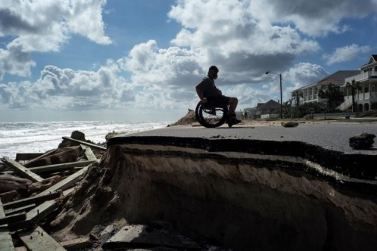 Una persona con disabilità in carrozzina lungo una parte di un’autostrada distrurtta dall’Uragano Matthew a Flagler Beach, in Florida, il 9 ottobre 2016 (© Jewel Samad/AFP/Getty Images)