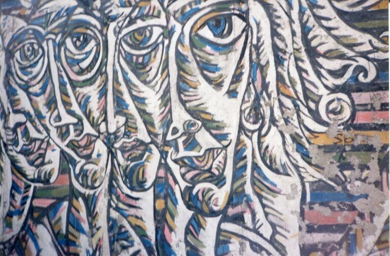 Murales raffigurante i volti stilizzati di diverse persone (foto di Simona Lancioni, Muro di Berlino, 2002).