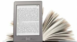 Un e-reader, vale a dire un lettore di libri digitali, ed un libro cartaceo.