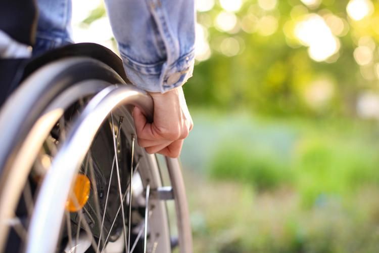 Persona con disabilità su carrozzina - Canva
