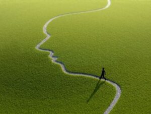 Una realizzazione grafica raffigura la sagoma di una persona su un campo verde che segue un sentiero la cui forma disegna il profilo di un volto umano.